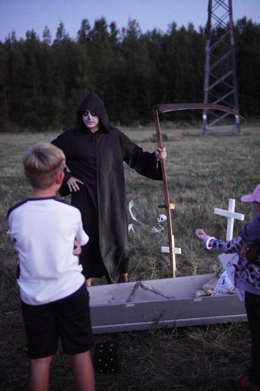 smrťák s&nbsp;kosou láká do&nbsp;rakve kolemjdoucí